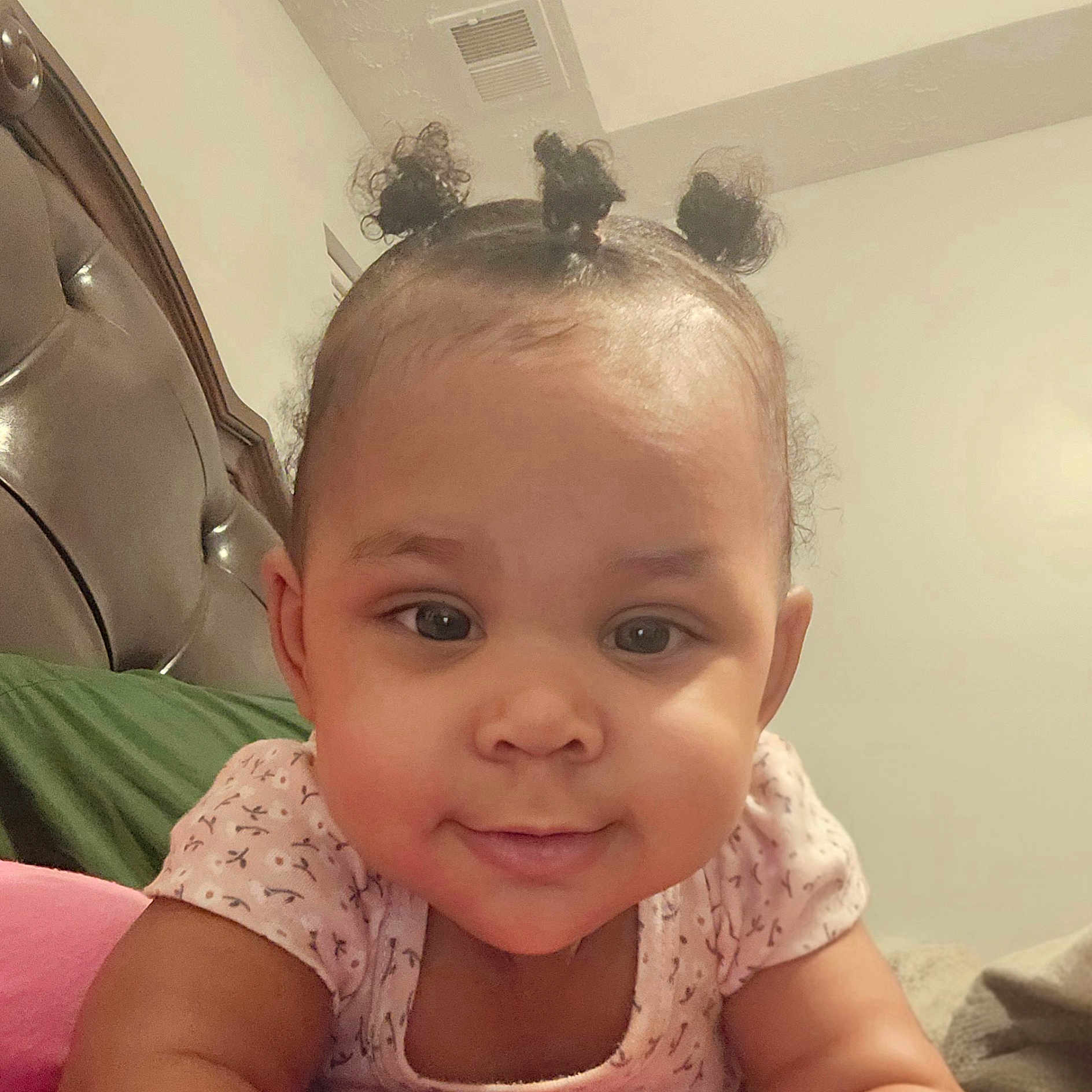 Marlie joined the competition — help win amazing prizes! baby, bedroom, cheeks, child, closeup, cute, eyes, face, hair_buns, happy, headboard, indoors, infant, lying_down, onesie, pillow, portrait, skin, smile, toddler