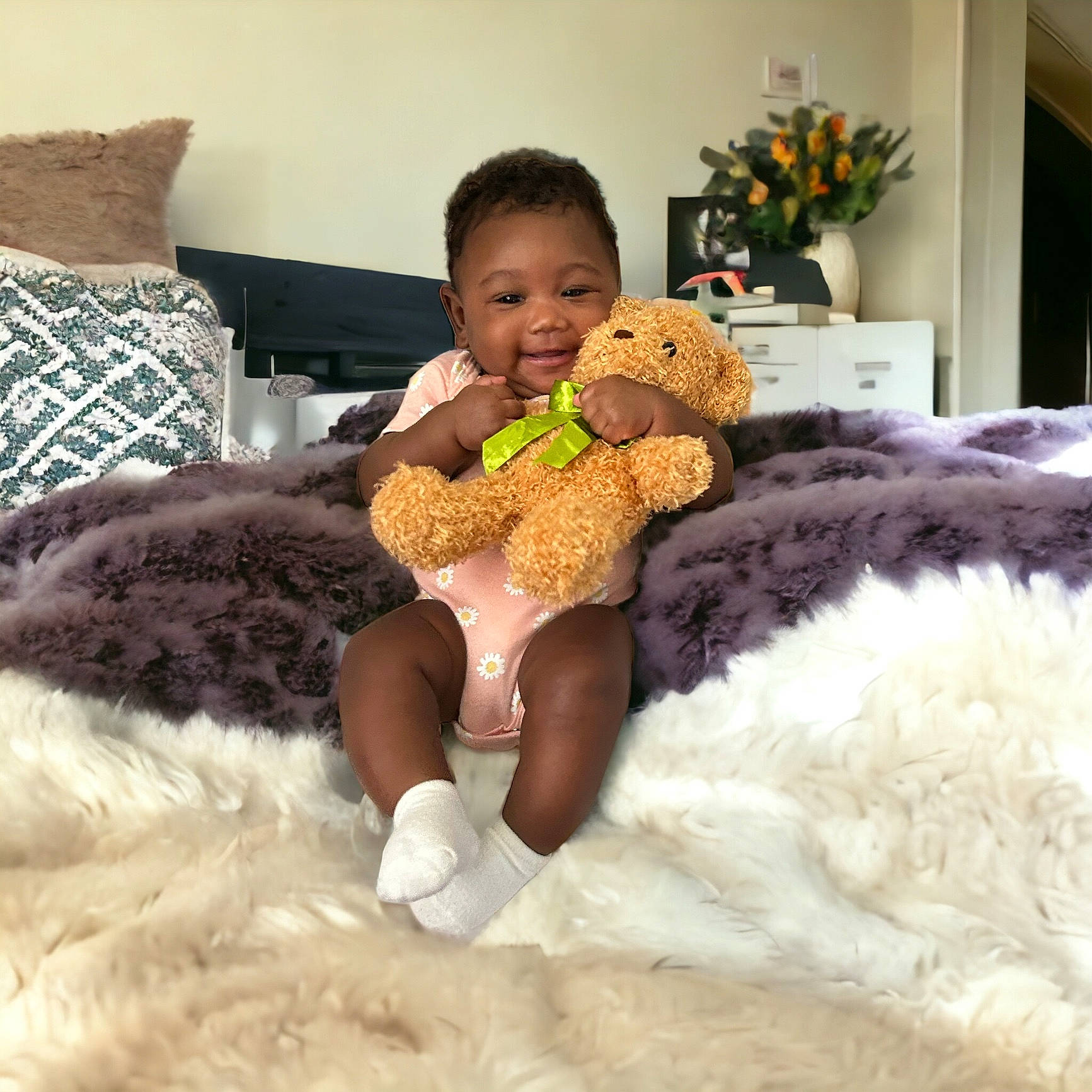 Amaya joined the competition — help win amazing prizes! bed, bedding, comfort, couch, flowerpot, fur, joy, linens, mammal, person, plant, plush, room, smile, stuffed_toy, teddy_bear, textile, thigh, toddler, toy
