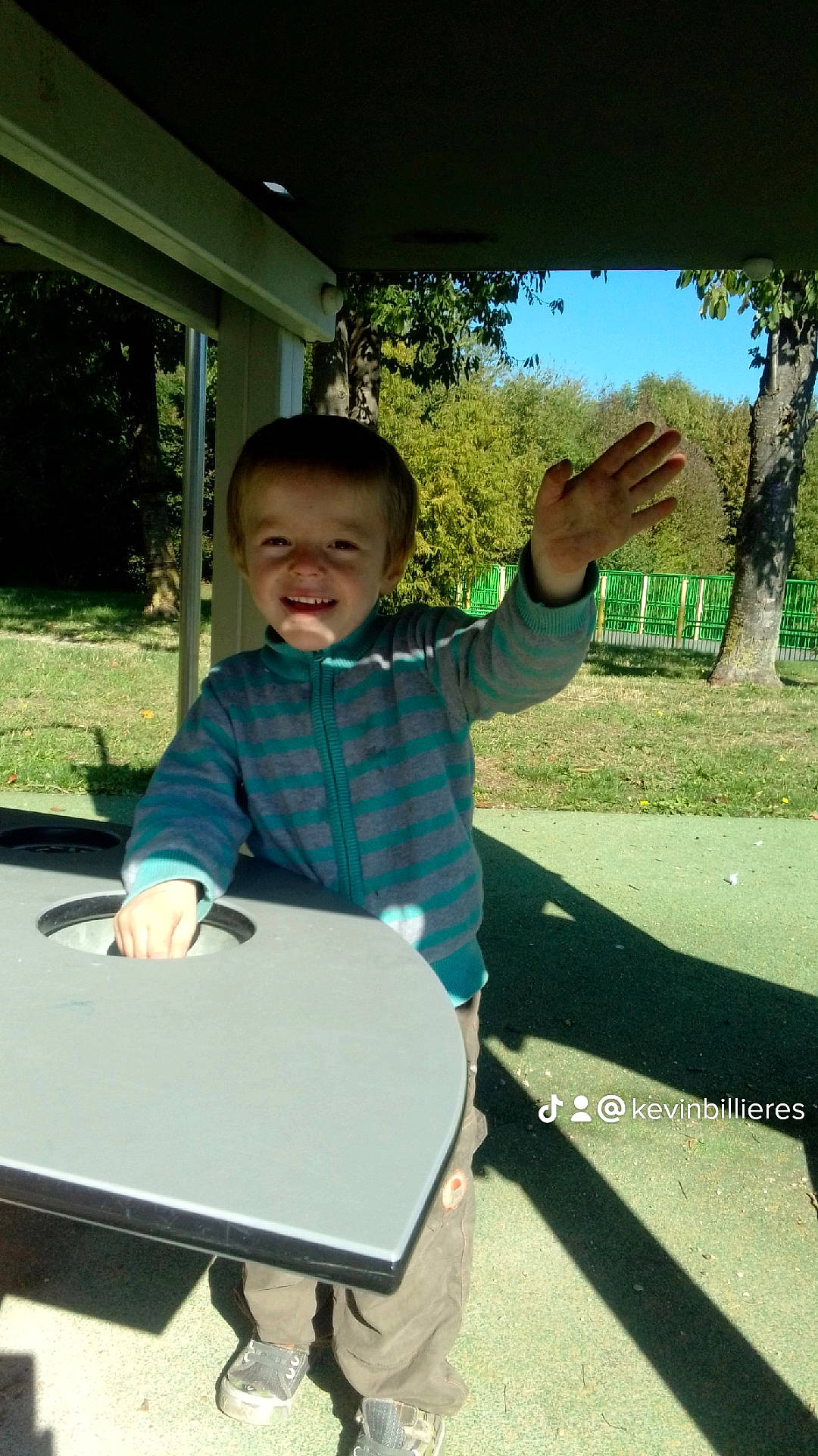 Kylan participe au concours pour gagner de l'argent avec cette photo : child, city, fun, gesture, grass, happy, joy, leisure, person, plant, play, recreation, shade, sitting, sky, sleeve, smile, t_shirt, toddler, travel