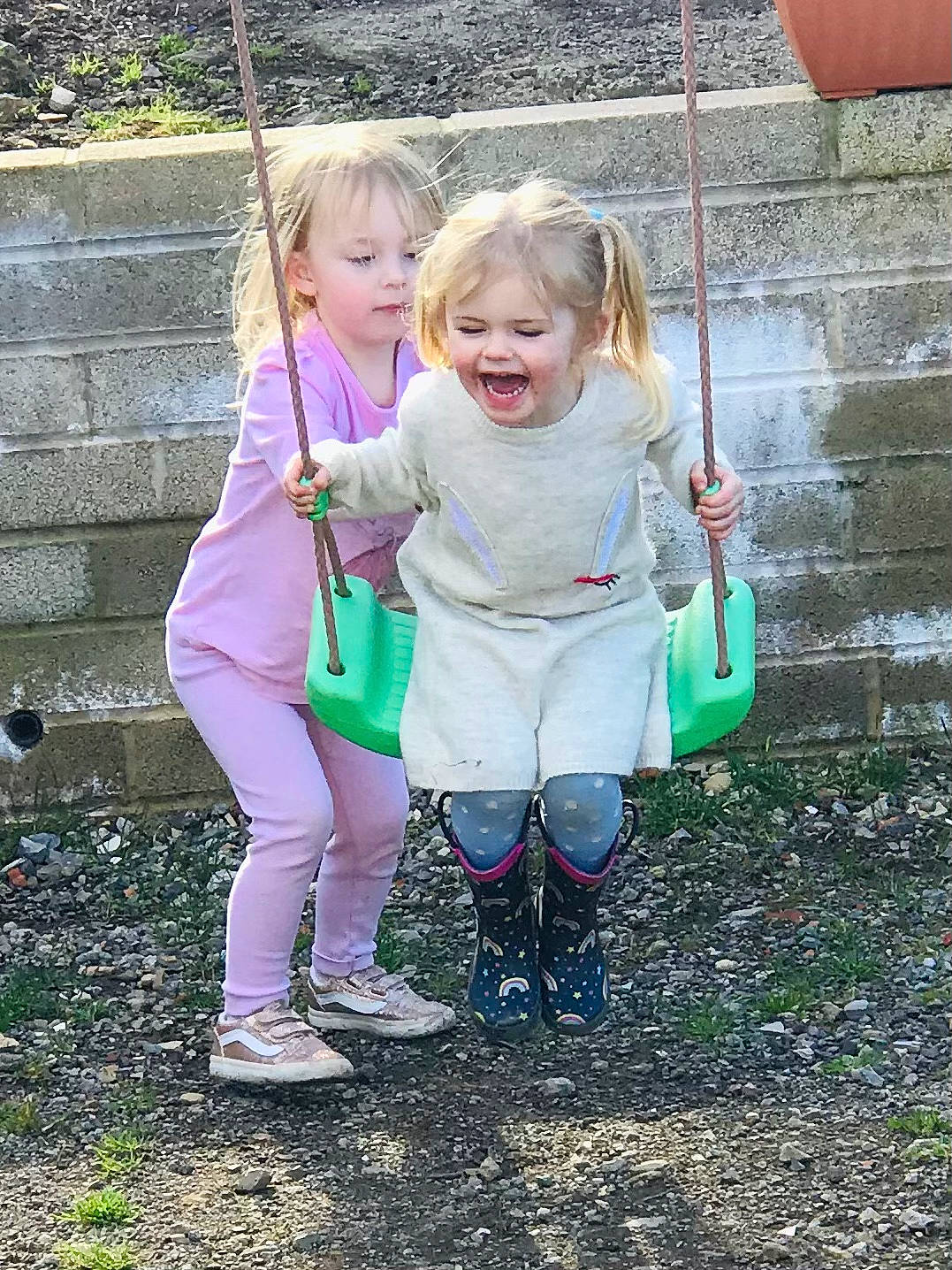 Ava is registered to the contest to win money with this photo: child, face, fun, gesture, grass, hand, happy, leaf, leisure, nature, people, people_in_nature, person, pink, plant, recreation, sitting, smile, summer, toddler