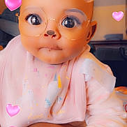 Keonna is registered to the contest to win money with this photo: arm, baby, bear_ears, bib, child, closeup, clothing, cute, digital_effect, face_filter, glasses, hand, indoor, infant, person, pink_hearts, portrait, smile, soft_lighting, unicorn_pattern