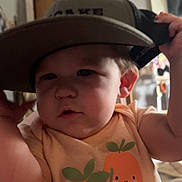 Ayvah joined the competition — help win amazing prizes! toddler, child, hat, cap, indoor, cute, baby, face, expression, clothing, shirt, fruit_print, orange, cherry, person, headwear, smile, young_child, arm, casual