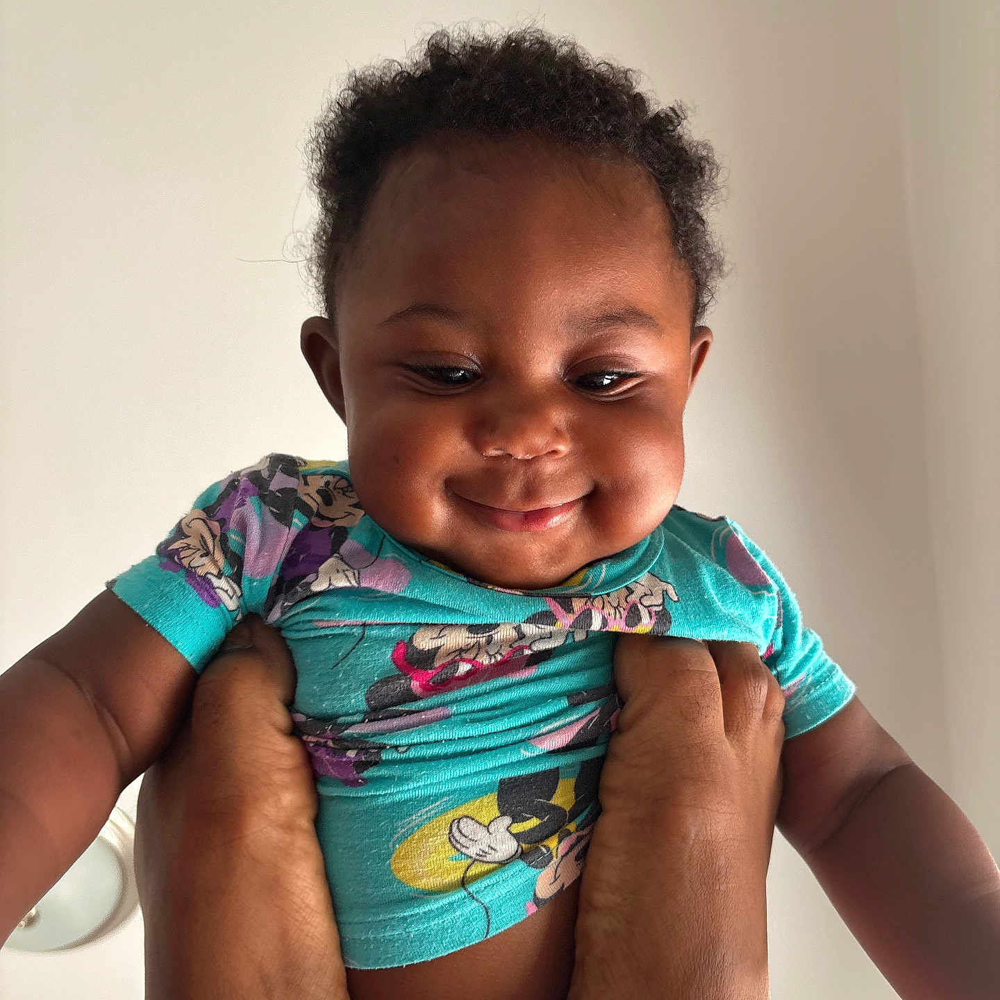 Aylani is registered to the contest to win money with this photo: baby, child, smile, hands, shirt, cartoon, playful, portrait, cute, indoor, person, happy, infant, young_child, skin, head, face, expression, clothing, background