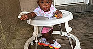 Aylani is registered to the contest to win money with this photo: baby_walker, brick_wall, candid, child, clothing, colorful_sneakers, curious, cute, door, exploring, footwear, indoors, person, pink_bows, playful, porch, snack, toddler, wooden_floor, young_child