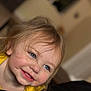 toddler, child, smiling, face, blue_eyes, blonde_hair, indoor, portrait, close_up, yellow_clothing, happy, cute, young_child, person, skin, head, hair, expression, baby, cheerful