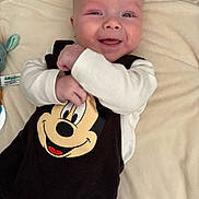 Roméo participe au concours pour gagner de l'argent avec cette photo : baby, infant, smiling, mickey_mouse, blanket, onesie, plush_toy, crib, cheeks, eyes, hand, portrait, closeup, happy, newborn, lying_down, nursery, soft_fabric, clothing, bunny_prints