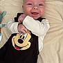 baby, infant, smiling, mickey_mouse, blanket, onesie, plush_toy, crib, cheeks, eyes, hand, portrait, closeup, happy, newborn, lying_down, nursery, soft_fabric, clothing, bunny_prints