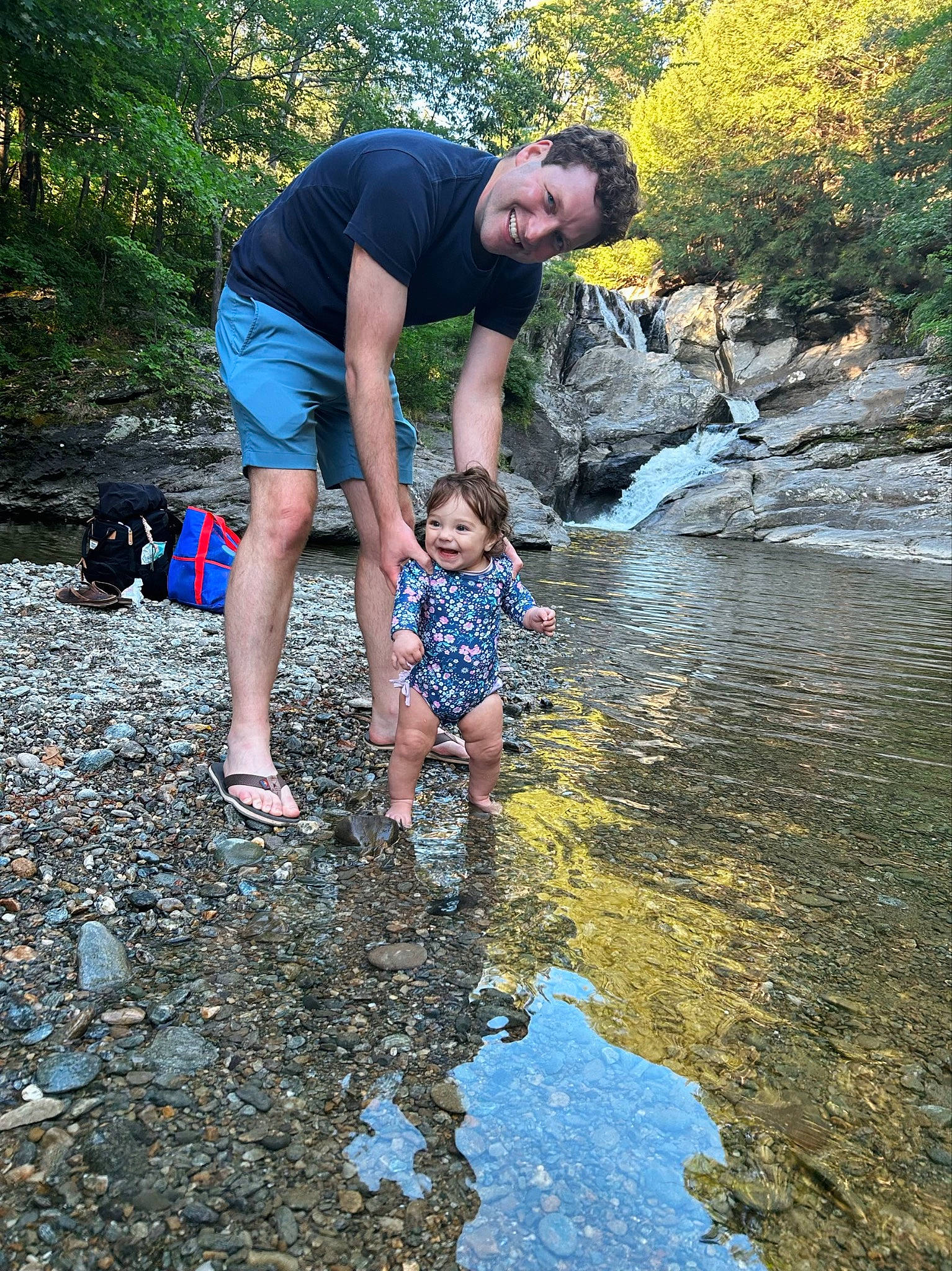 Eve is registered to the contest to win money with this photo: bank, creek, fluvial_landforms_of_streams, fun, grass, joy, lake, landscape, leisure, natural_landscape, people_in_nature, person, plant, recreation, rock, stream, toddler, tree, vertebrate, water
