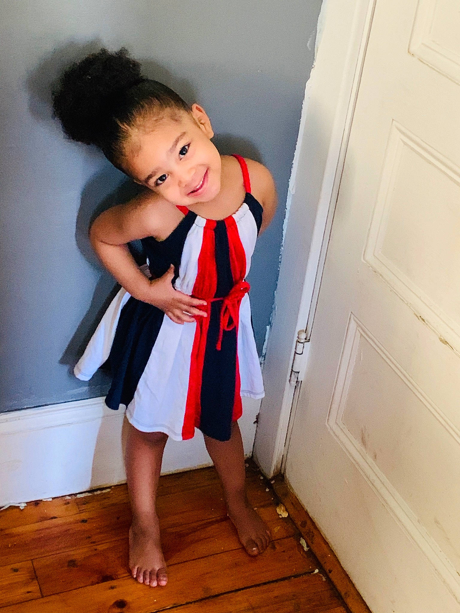 Angelyn is registered to the contest to win money with this photo: child, child_model, clothing, costume, dress, footwear, human_leg, joint, joy, leg, person, red, room, shoe, shoulder, standing, toddler, white