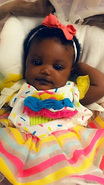 Amari is registered to the contest to win money with this photo: baby, baby_products, baby_toddler_clothing, cheek, child, face, hair_accessory, head, lip, mouth, person, pink, product, skin, smile, textile, toddler