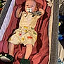 baby, infant, pacifier, bassinet, blanket, slippers, dinosaur_slippers, clothing, toddler, sleeping_area, soft_toy, indoor, child, cute, lying_down, comfortable, home, fabric, toy, person