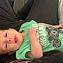 Kendan joined the competition — help win amazing prizes! baby, infant, child, onesie, green_clothing, monster_truck, tongue_out, hand, skin, person, lying_down, comfort, casual, cute, playful, head_touch, relaxation, indoors, fabric, soft
