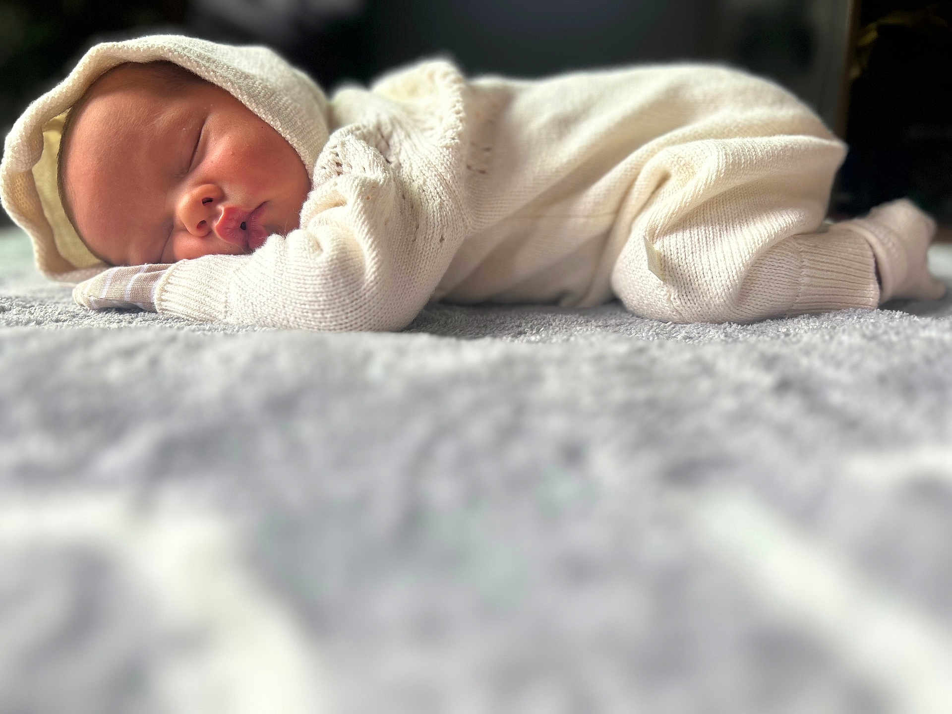 Prince is registered to the contest to win money with this photo: baby, sleeping, infant, knitwear, hood, soft_texture, blanket, cozy, peaceful, closeup, portrait, child, resting, cute, warm, indoors, newborn, comfort, still_life, soft_lighting