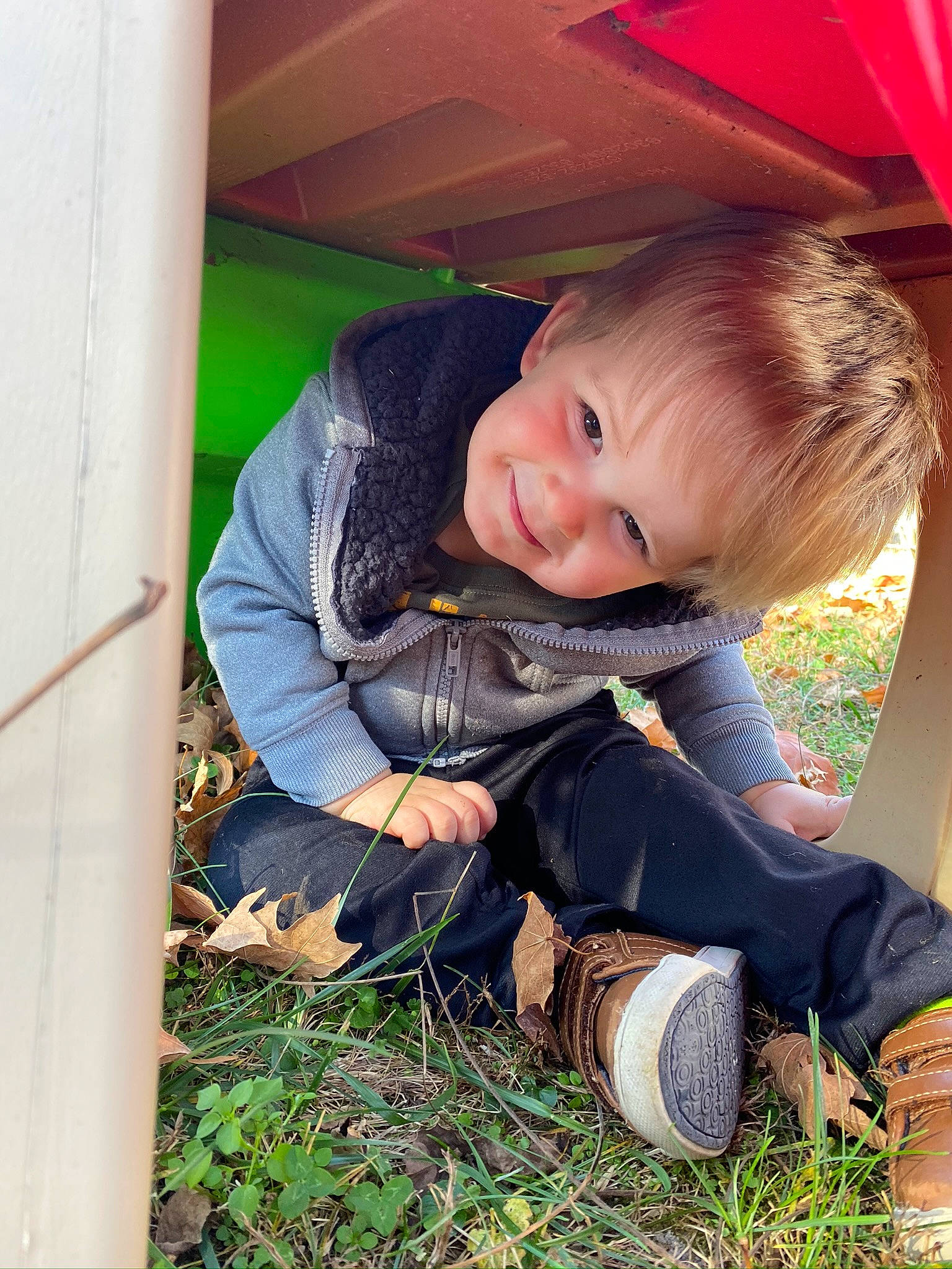 Zaiden is registered to the contest to win money with this photo: beauty, blond, boot, child, facial_expression, fun, grass, hairstyle, happy, joy, leisure, people_in_nature, person, plant, play, sitting, skin, smile, sneakers, toddler