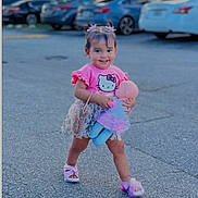 Zara Cataleya joined the competition — help win amazing prizes! toddler, child, girl, toy, doll, pink, sandals, hair_clips, smiling, parking_lot, sidewalk, purse, shorts, outdoor, cute, happy, walking, clothing, person, daytime