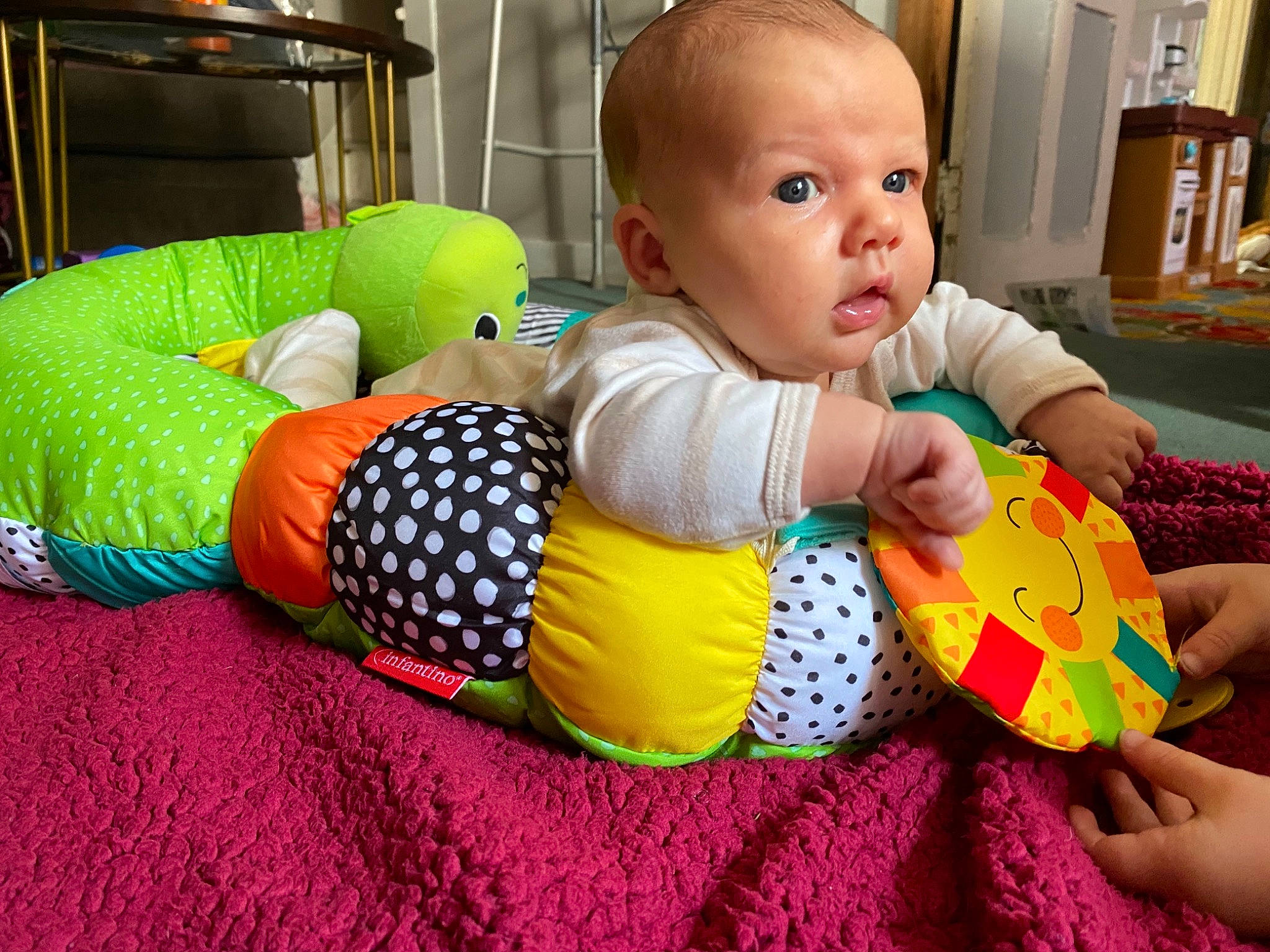 Colin is registered to the contest to win money with this photo: baby, baby_playing_with_toys, baby_products, baby_toddler_clothing, baby_toys, bookcase, child, comfort, flooring, fun, happy, linens, person, play, product, room, shelf, sitting, stuffed_toy, toddler