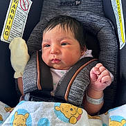 Serenity is registered to the contest to win money with this photo: baby, newborn, car_seat, blanket, mittens, hospital_bracelet, winnie_the_pooh, pacifier, infant, face, person, child, cute, indoors, safety_harness, clothing, seat, expression, young, resting