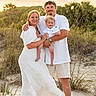 family, child, toddler, beach, sand, sunset, grass, nature, smile, happy, outdoor, portrait, barefoot, casual_clothing, white_dress, shorts, father, mother, holding, together