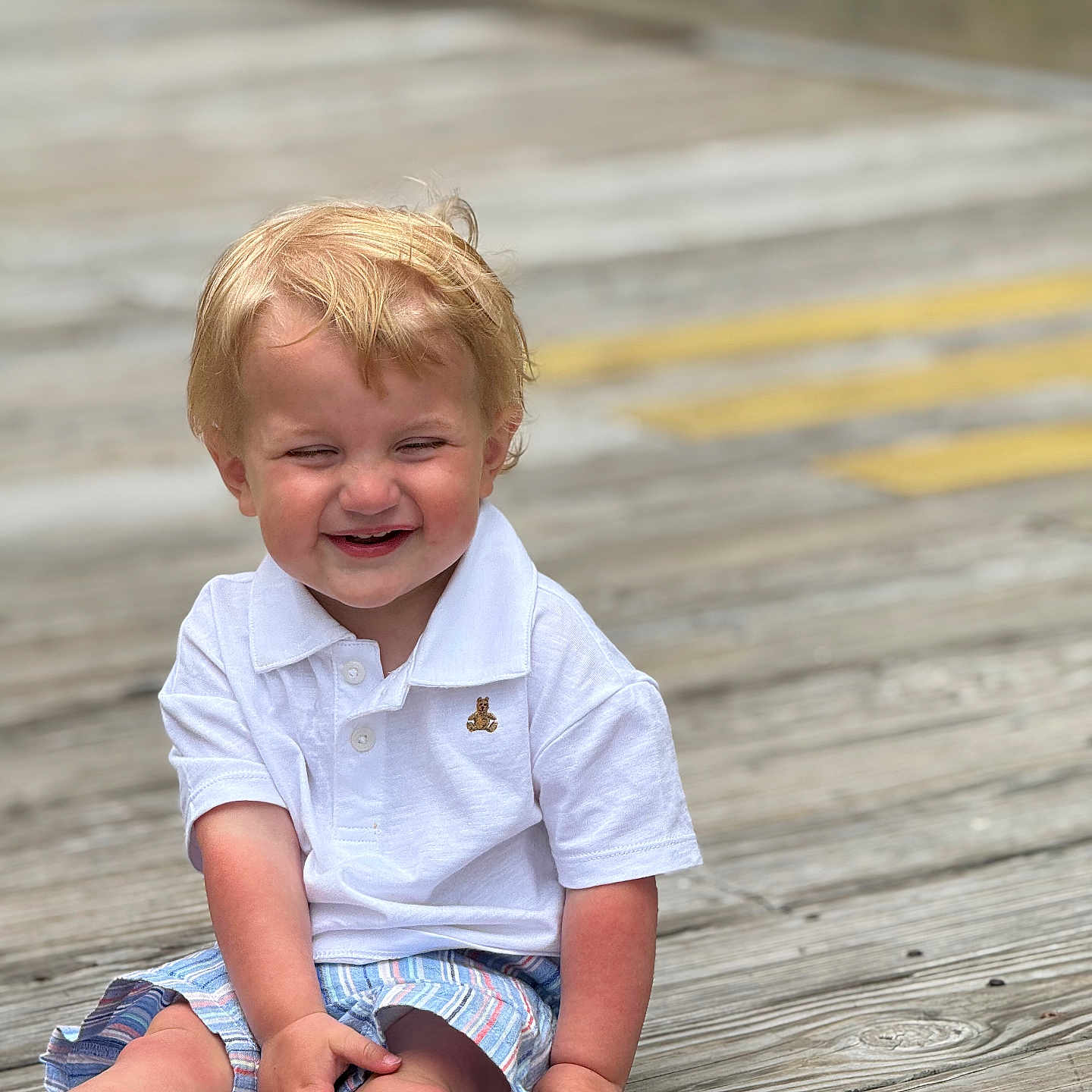 Hardin joined the competition — help win amazing prizes! toddler, child, smiling, white_polo, striped_shorts, socks, blonde_hair, outdoor, boardwalk, wooden_floor, happy, cute, sitting, sunlight, casual_clothing, portrait, baby, funny_face, young_child, playful