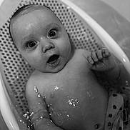 Lilith is registered to the contest to win money with this photo: baby, bath, water, infant, child, smile, face, skin, hand, mouth, eyes, wet, bathtub, expression, young, cute, splash, seat, black_and_white, portrait