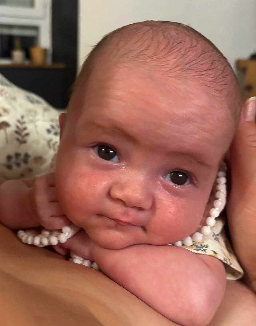 Miley a rejoint le concours — aidez-le/la à gagner de superbes lots ! baby, face, child, closeup, portrait, skin, eyes, arm, hand, necklace, clothing, indoor, person, infant, cute, expression, resting, head, soft_light, warm