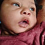 Natalie is registered to the contest to win money with this photo: baby, child, chubby_cheeks, close_up, curly_hair, cute, expression, eyes, face, head, indoors, infant, looking_away, maroon_clothing, mouth, person, portrait, skin, soft_light, young