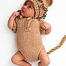 baby, infant, knitted_clothing, bear_costume, cute, lying_down, white_background, newborn, hand_knit, headwear, ears, tail, fist, feet, looking_up, portrait, soft_texture, child, adorable, cozy