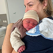 Anastasia a rejoint le concours — aidez-le/la à gagner de superbes lots ! newborn, baby, adult, woman, holding, sleeping, hat, knitted_clothing, towel, indoor, close_up, face, skin, arm, comfort, care, love, family, portrait, person