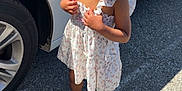 Miracle is registered to the contest to win money with this photo: accessories, asphalt, car, child, cute, dress, earrings, fashion, hair_buns, happy, outdoor, parking_lot, person, smiling, standing, sunlight, toddler, vehicle, white_sandals, young_child