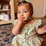 baby, biting, bodypart, clothing, couch, dress, eating, face, finger, food, furniture, hand, hardwood, head, person, photography, portrait, sitting, sweets, wood