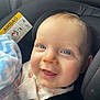 baby, blue_eyes, car_seat, child, blanket, smile, infant, cute, seatbelt, clothing, face, closeup, happy, indoor, safety, head, skin, person, young_child, comfort