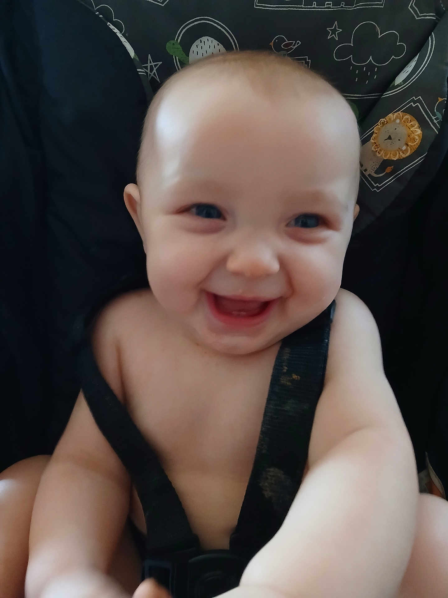River is registered to the contest to win money with this photo: baby, smiling, infant, car_seat, safety_strap, happy, child, cute, face, cheerful, seat, young, portrait, person, skin, blue_eyes, expression, childhood, indoors, seatbelt