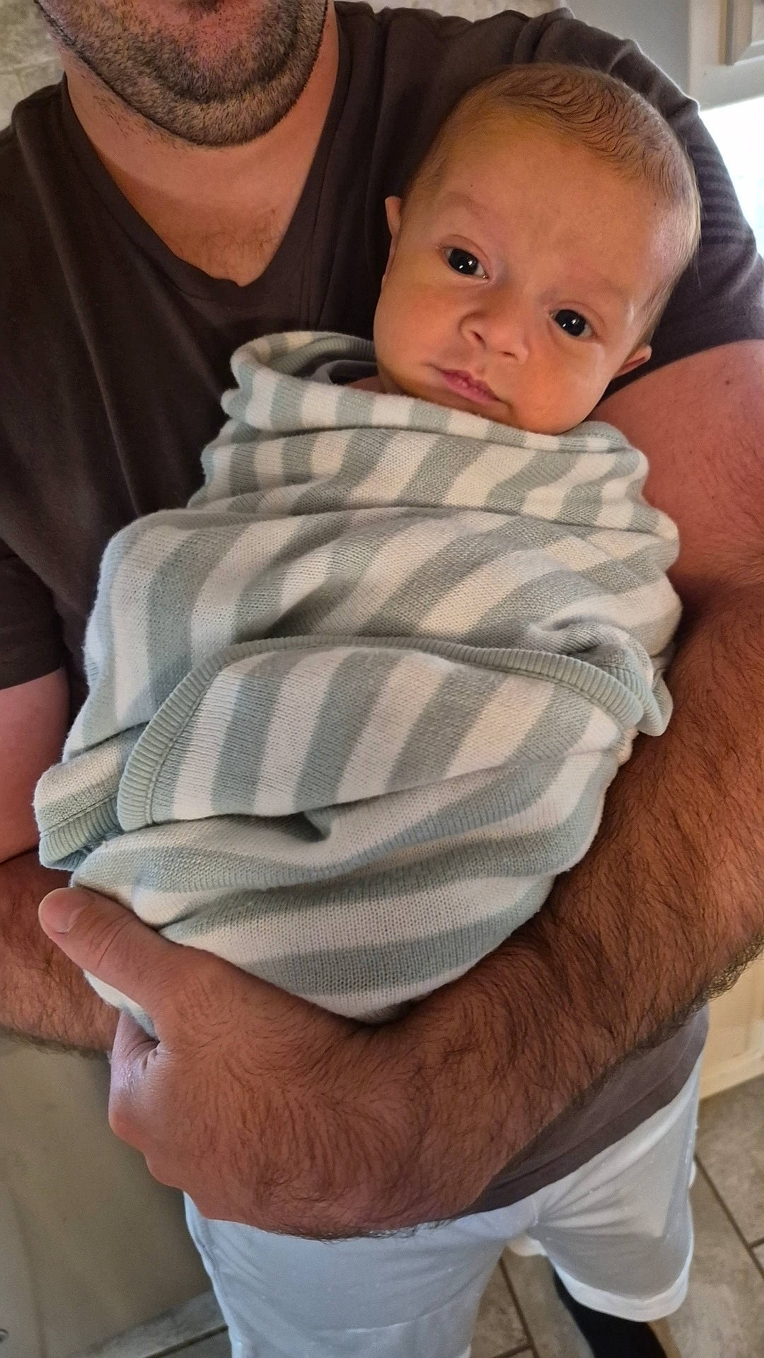 Merritt joined the competition — help win amazing prizes! adult, arms, baby, blanket, casual, closeup, clothing, comfort, curious, face, holding, home, human_skin, indoor, infant, person, portrait, striped_blanket, toddler, wrapped