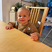 Maël participe au concours pour gagner de l'argent avec cette photo : baby, bodypart, chair, diningtable, face, finger, furniture, hand, hardwood, head, indoors, interiordesign, person, photography, plywood, portrait, sitting, table, tabletop, wood