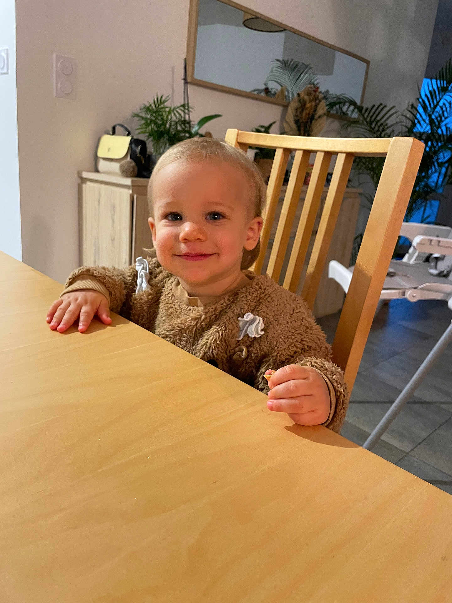 Maël participe au concours pour gagner de l'argent avec cette photo : baby, bodypart, chair, diningtable, face, finger, furniture, hand, hardwood, head, indoors, interiordesign, person, photography, plywood, portrait, sitting, table, tabletop, wood