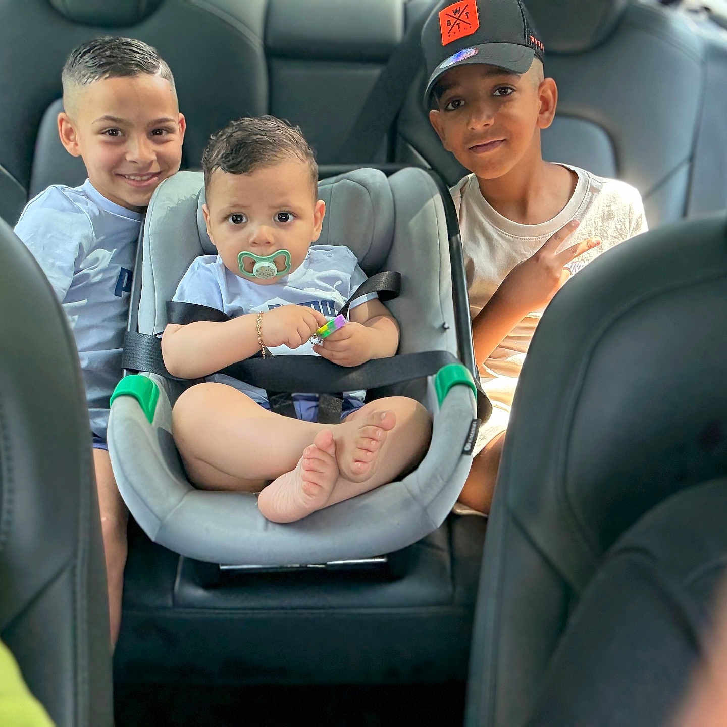 Jassim participe au concours pour gagner de l'argent avec cette photo : baby, bonding, brothers, car_interior, car_seat, casual_clothing, child, cute, family, happy, hat, indoors, pacifier, peace_sign, seatbelt, short_hair, sitting, smile, transportation, tshirt
