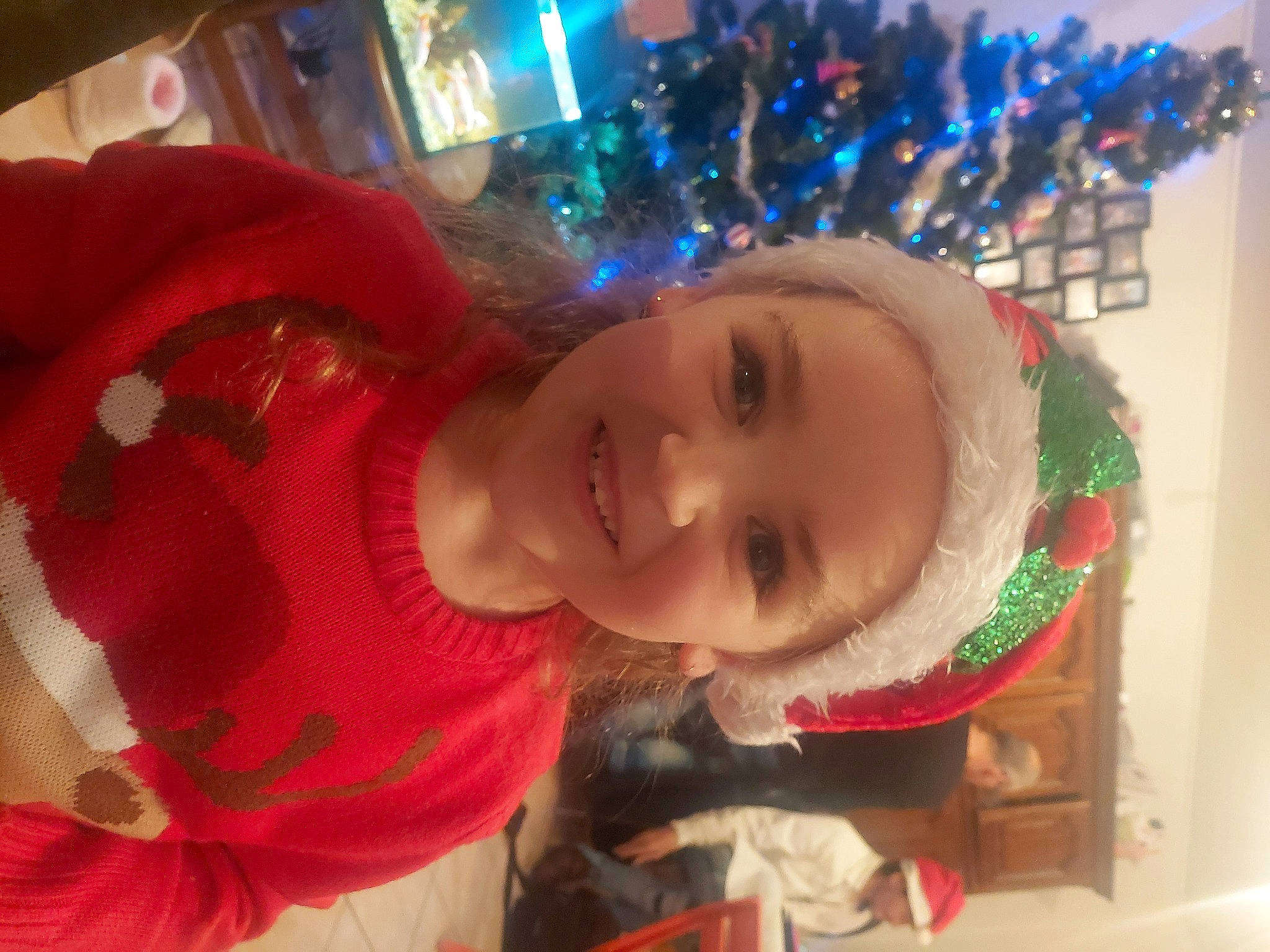 Jade participe au concours pour gagner de l'argent avec cette photo : carmine, child, christmas, christmas_decoration, christmas_eve, christmas_ornament, christmas_tree, event, facial_expression, fun, happy, headwear, holiday, holiday_ornament, joy, ornament, person, plant, room, smile