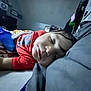 Mateo is registered to the contest to win money with this photo: child, sleeping, blanket, pillow, bed, indoor, cozy, peaceful, resting, face, person, bottle, clothing, red_shirt, hair, furniture, room, soft, relaxation, nap