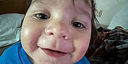 Mateo joined the competition — help win amazing prizes! child, toddler, smiling, blue_shirt, face, close_up, bedroom, bed, blanket, wallpaper, indoor, person, happy, curly_hair, cute, young_child, portrait, casual_clothing, home, cozy