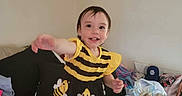 Nova joined the competition — help win amazing prizes! toddler, child, smiling, dress, bee_pattern, bed, blanket, pillow, indoor, person, clothing, happy, young_child, home, furniture, fabric, reaching, cute, casual, joyful