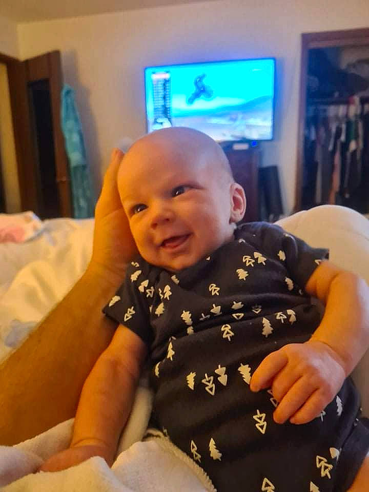 Logan joined the competition — help win amazing prizes! baby, baby_toddler_clothing, cheek, comfort, display_device, eye, flooring, fun, happy, head, iris, mouth, person, room, sitting, skin, sleeve, smile, television, thumb