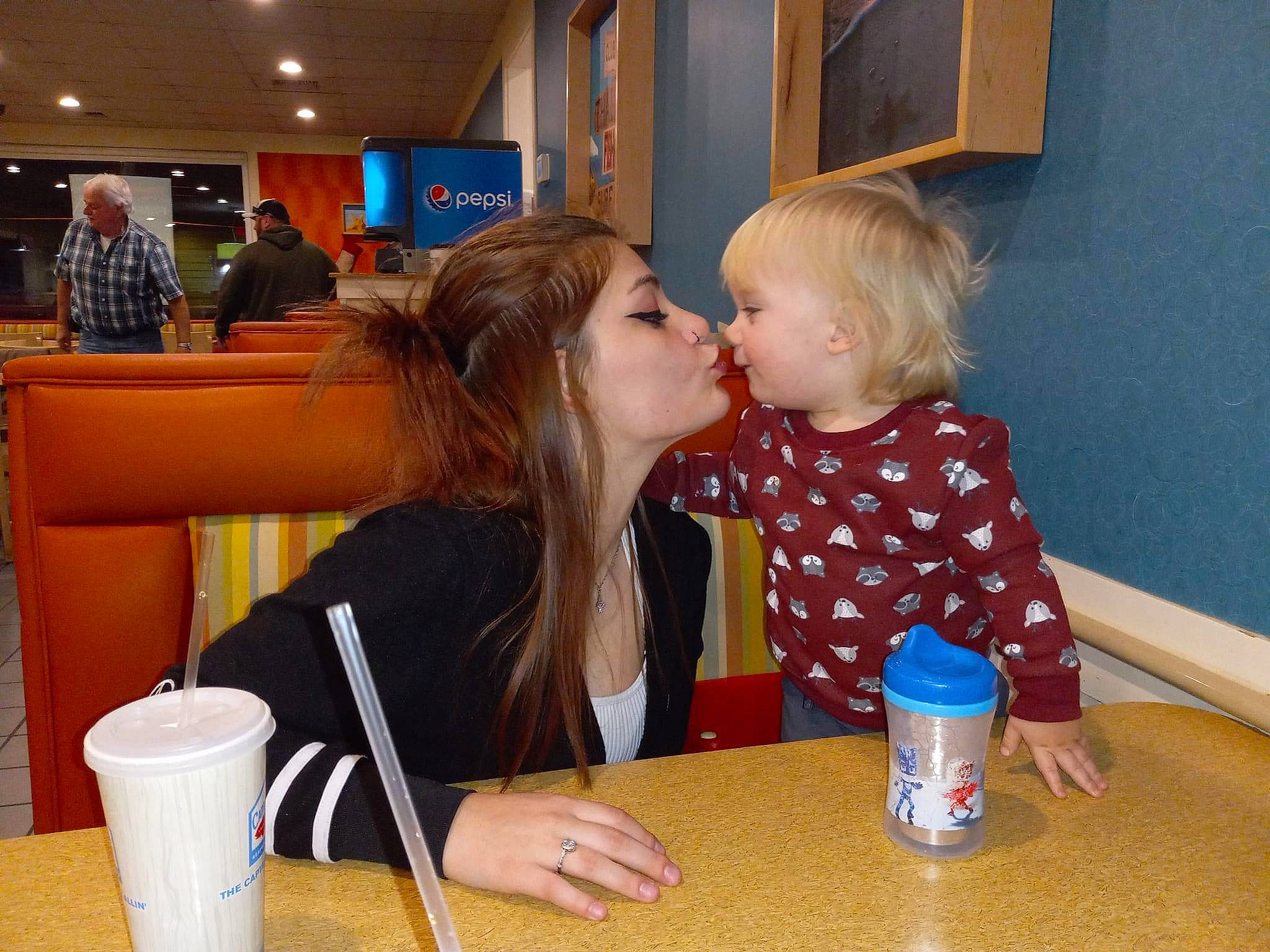 Zayvier joined the competition — help win amazing prizes! blond, chair, child, cup, desk, drink, drinkware, event, flooring, fun, hairstyle, kiss, leisure, person, plate, sharing, sitting, t_shirt, table, toddler