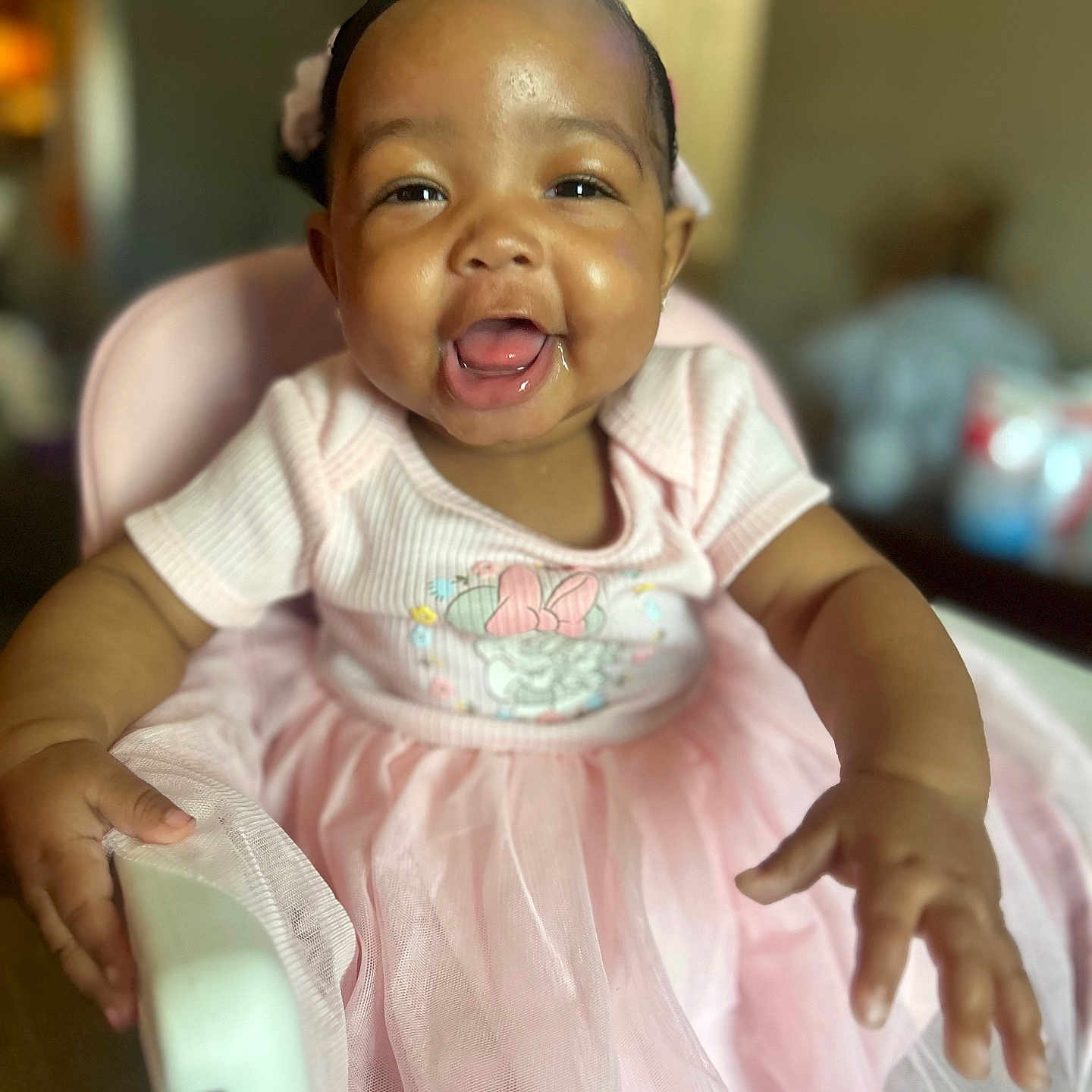 Ava joined the competition — help win amazing prizes! baby, child, infant, smile, happy, pink_dress, high_chair, indoor, face, hands, drool, cute, person, portrait, seated, tulle_skirt, headband, skin, eyes, baby_girl