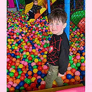 Tayron participe au concours pour gagner de l'argent avec cette photo : ball_pit, blue, casual_clothing, child, climbing, colorful, fence, fun, green, happy, indoor, kid, orange, pink, plastic_balls, play, playground, slide, smile, yellow
