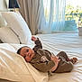 Elio a rejoint le concours — aidez-le/la à gagner de superbes lots ! baby, bed, pillow, blanket, curtain, window, sock, clothing, infant, indoor, lamp, furniture, relaxing, cozy, soft_light, person, portrait, white_bed, knitwear, balcony