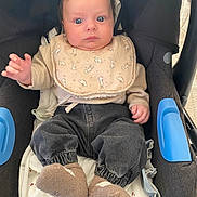 Elio a rejoint le concours — aidez-le/la à gagner de superbes lots ! baby, bib, car_seat, clothing, cute, expression, face, indoor, infant, legs, person, portrait, socks, seat, sitting, small_child, soft_toys, wearing, young_child, hands