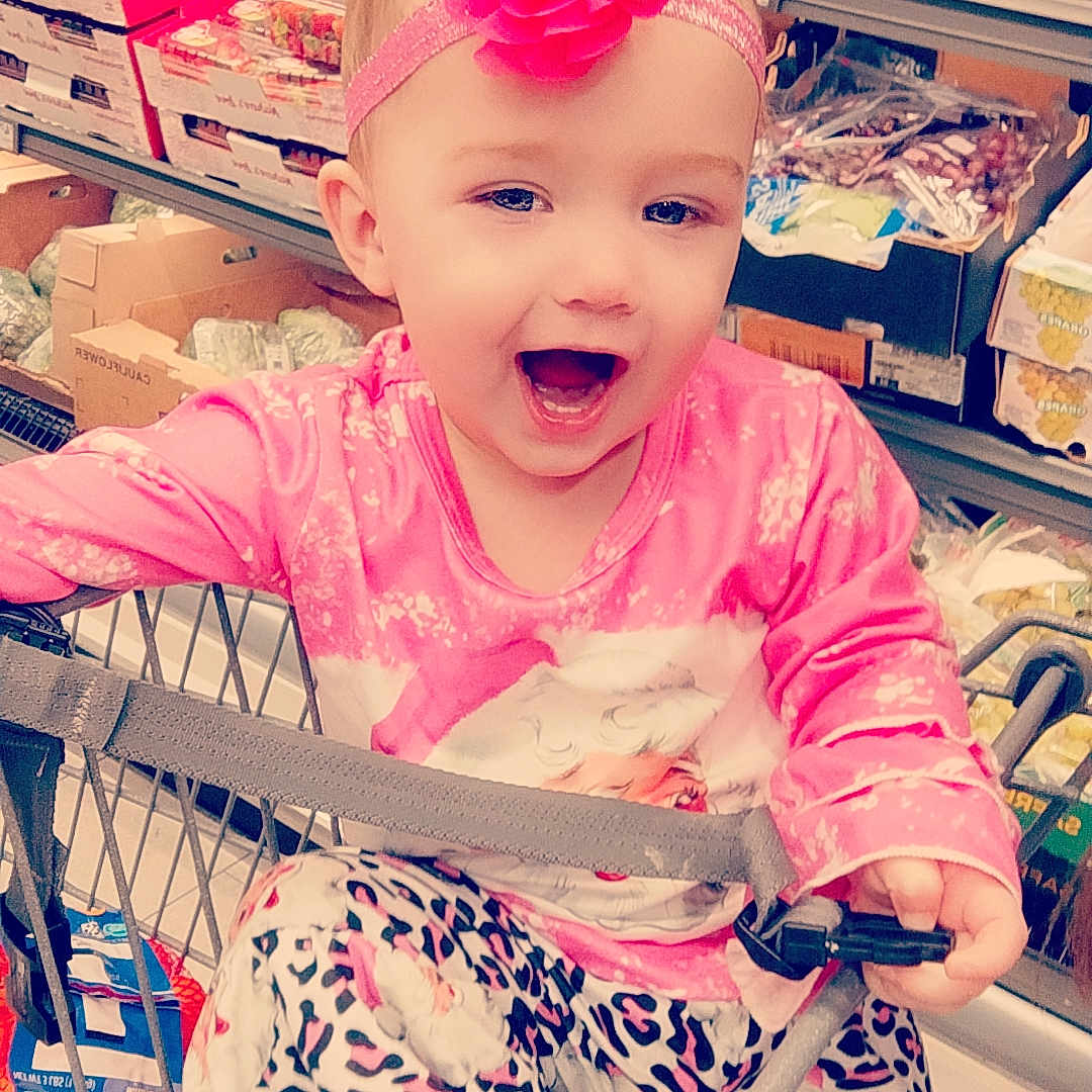 Gracelynn is registered to the contest to win money with this photo: accessories, baby, candy, clothing, coat, dress, face, food, glasses, happy, head, indoors, person, photography, portrait, shelf, shop, shopping, shoppingcart, sweets
