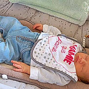 Thelyo a rejoint le concours — aidez-le/la à gagner de superbes lots ! baby, bed, blanket, clothing, crib, cushion, furniture, hat, homedecor, infantbed, jeans, newborn, pants, person, sleeping