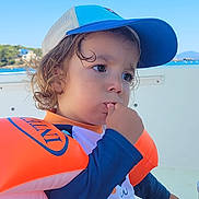 Ziggy participe au concours pour gagner de l'argent avec cette photo : blue_sky, boat, cap, child, clothing, curly_hair, life_jacket, nature, outdoor, pensive, portrait, shorts, sitting, sky, summer, sunny, thumb_sucking, toddler, vacation, water