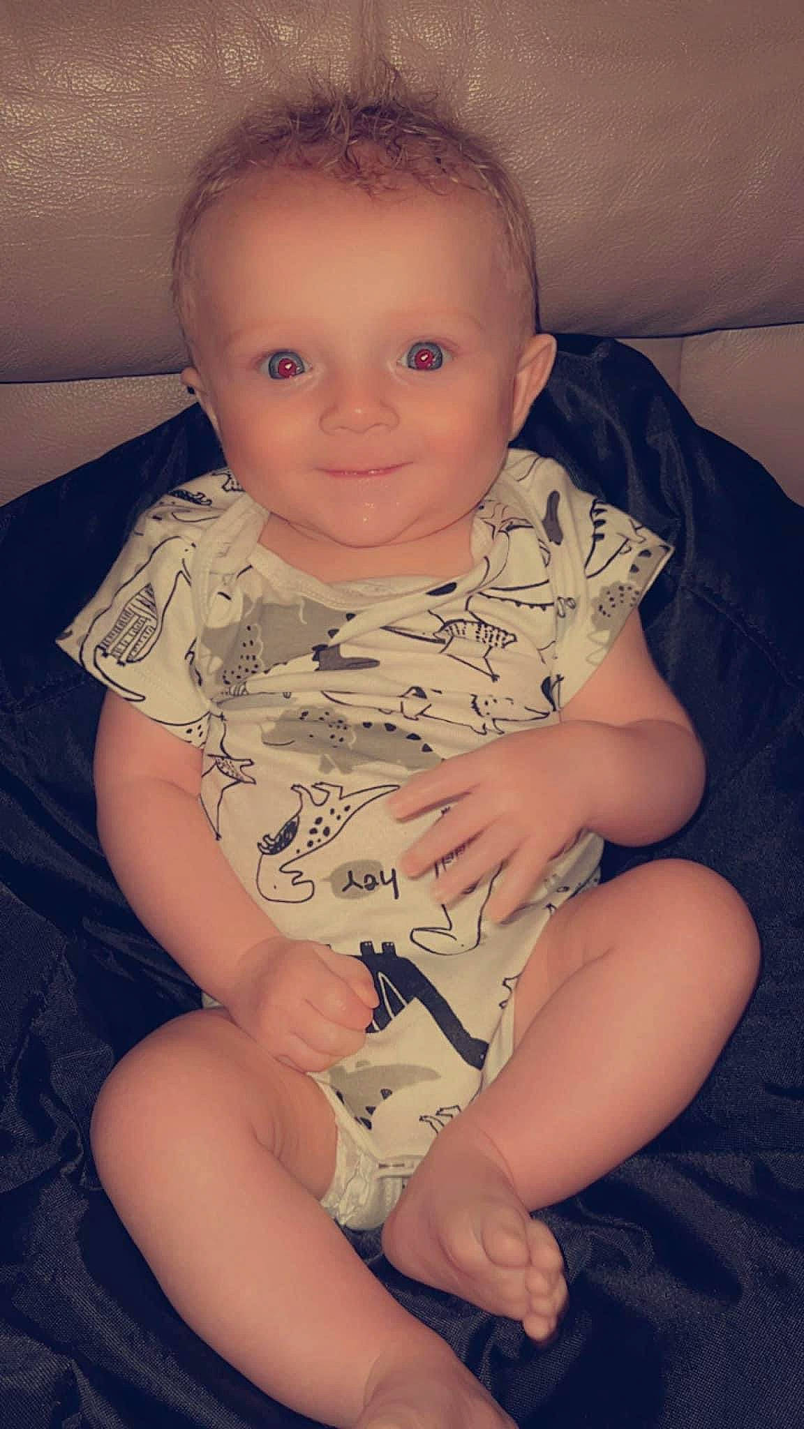 Branson is registered to the contest to win money with this photo: arm, baby_toddler_clothing, cheek, comfort, eye, finger, happy, human_body, knee, leg, lip, mouth, neck, nose, organ, person, skin, sleeve, smile, stomach